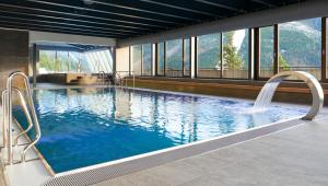 a large swimming pool with a waterfall in a building at OREA Resort Horal Špindlerův Mlýn in Špindlerův Mlýn