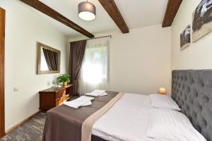 a bedroom with a large bed and a window at Medžiotojų Sostinė in Kunioniai