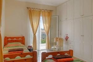 a bedroom with two beds and a window at Villa Aglaia in Corfu