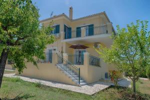 a large yellow house with stairs in front of it at Villa Aglaia in Corfu