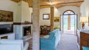 a living room with blue chairs and a fireplace at Ca' Pellicciano 8, Emma Villas in Longiano