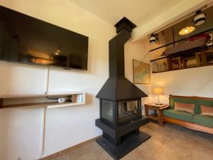 - un salon avec une cheminée et un canapé vert dans l'établissement Apartament a La Molina, grans vistes, llar de foc, à La Molina