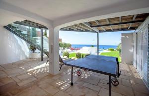 un tavolo da ping pong su un patio con vista sull'oceano di Luxurious BEACHFRONT VILLA de la PLAGE with private beach acces ad Albufeira