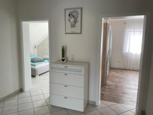 Vestidor blanco en una habitación con dormitorio en Ferienwohnung Nova, en Tholey