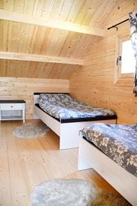 a room with two beds in a log cabin at Domek pod Sosnami z posesją na wyłączność Mazury Prażmowo in Prażmowo