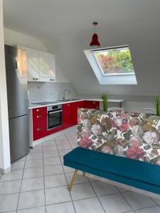 cocina con armarios rojos y sofá azul en Ferienwohnung Nova, en Tholey