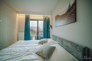 a bedroom with a large bed with blue curtains at Apartament Silence Karpatia Resort Zelda in Karpacz