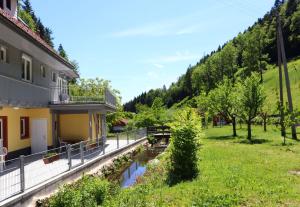 - une vue sur une maison avec une rivière dans la cour dans l'établissement Haus Belchenwiese, à Kleines Wiesental