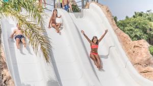 a group of people sliding down a slide at a water park at Alannia Els Prats in Montroig