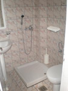 een badkamer met een douche, een toilet en een wastafel bij Oasis in Amoudi