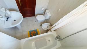 a bathroom with a sink and a toilet and a tub at Apartamentos San Vicente Playa in San Vicente de la Barquera