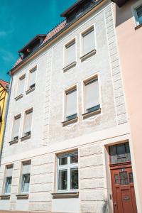 a white brick building with a red door at 4 Sterne Ferienwohnung , 65 qm in Quedlinburg