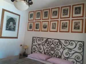 - une chambre avec un lit et des photos sur le mur dans l'établissement Casa Intignano - Camera con bagno e portico vista lago, à Tremezzo