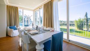 a dining room with a table and a large window at La Perla tra gli Ulivi 12, Emma Villas in San Vincenzo