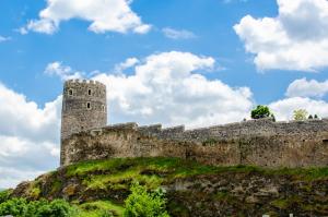 a castle on top of a hill with a blue sky at Light House Old City in Akhaltsikhe