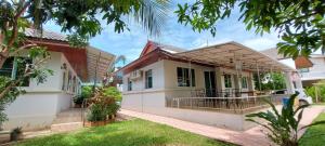 a house in the suburbs with a yard at Nuch's Apple Guest House in Si Bun Ruang