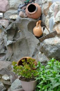 a stone wall with two pots and a potted plant at Light House Old City in Akhaltsikhe