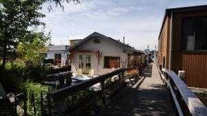 a house with a wooden walkway next to a building at Houseboat apartment with water terrace, free bikes & fast wifi in Amsterdam