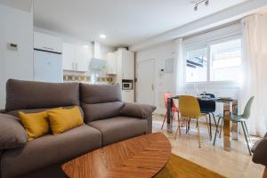 a living room with a couch and a table at Triana Boutique Free Parking in Seville