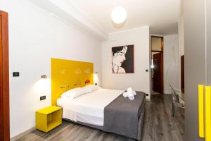 1 dormitorio con cama blanca y pared amarilla en Hotel Cristallo Torino, en Turín