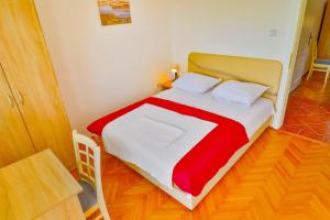 a bedroom with a bed with a red and white blanket at VIVANA HOUSE in Bar, Susanj