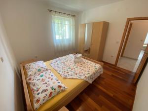 a bedroom with a bed with a comforter on it at Apartments Malinska - apartment 1 in Malinska