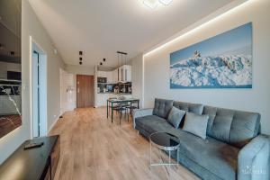 sala de estar con sofá azul y mesa en Apartament Silence Karpatia Resort Chalcedon, en Karpacz