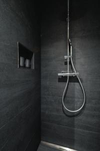 a shower in a bathroom with a black wall at CHICLIVING Appartements in St. Wolfgang +11 photos