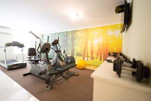 een fitnessruimte met loopbanden en een muurschildering bij The Andros Boutique Hotel in Kaapstad