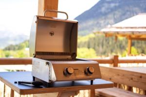 a grill on a table with a view of a mountain at Almdorf Vorderbrand in Schönau am Königssee