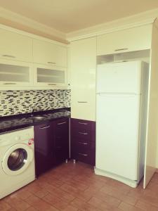 a kitchen with a white refrigerator and a washing machine at Trabzon Meydan in Trabzon