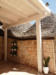 pérgola de madera sobre una pared de ladrillo en Trullo Paesano en Alberobello