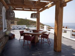 a patio with a table and chairs and the ocean at Toxotis Villas in Armenistis