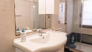 a white bathroom with a sink and a shower at Casa L'Alzoni in San Teodoro +30 photos