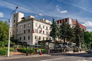 a large white building on a city street at Imperial Palace Hotel in Minsk