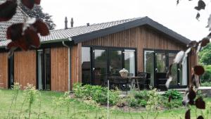 a house with glass doors and a table in the yard at Buitenlede 7 - Suite R in Dwingeloo