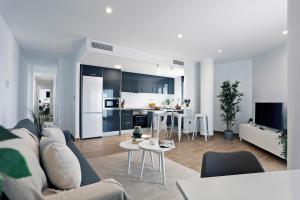 un soggiorno e una cucina con divano e tavolo di Rem Apartamentos a Torre-Pacheco