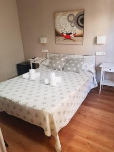 
a bedroom with a bed, table and a lamp at Hostal Termes in Sitges
