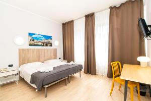 1 dormitorio con cama, escritorio y mesa en Hotel Cristallo Torino, en Turín