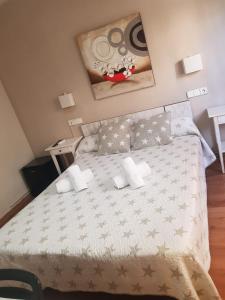 
a bedroom with a white bedspread and white pillows at Hostal Termes in Sitges
