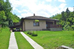 a small white house with a grass yard at Babakaj in Golubac