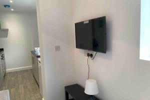 TV de pantalla plana colgada en la pared en Silver Stag Properties, Self-Contained Suite, en Donisthorpe