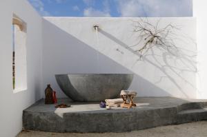 a white room with a concrete bench with a tub at Koufonisi Villas in Koufonisia