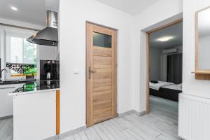 una cocina con una puerta que conduce a un dormitorio en VIP House Apartamenty, en Sztutowo
