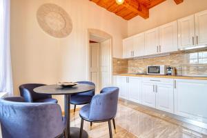 une cuisine avec une table et des chaises bleues dans l'établissement Manna Villa, à Eger