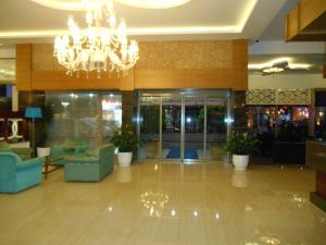 een lobby met stoelen en een kroonluchter in een gebouw bij Parador Beach Hotel in Alanya