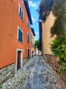 un chemin en pierre entre deux bâtiments situés dans une ruelle dans l'établissement Casa Tilde Guest House, à Cunardo