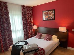 een hotelkamer met een bed met een koffer erop bij Appartéa Grenoble Alpexpo in Grenoble