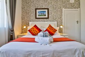 een slaapkamer met een groot wit bed met rode kussens bij Sunbury Bed and Breakfast in Johannesburg