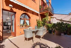 un patio con mesa y sillas y un edificio en Apartment below the stars, en Rovinj